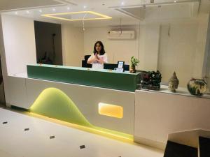 a woman standing at a counter in an office at TLS- The Lavish Stay in Varanasi