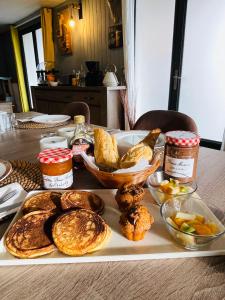 LacanOcéane Bed&Breakfast في لاكانو-أوسيان: طاولة مع صينية من الخبز وغيرها من الأطعمة