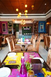 ein Restaurant mit einem Tisch und Stühlen sowie einer Bar in der Unterkunft HOTEL IMPERIAL EXECUTIVE in Ludhiana