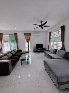 - un salon avec des canapés et un ventilateur de plafond dans l'établissement Homestay, à Sitiawan