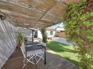 eine Terrasse mit Tisch und Stühlen unter einer Pergola in der Unterkunft Maison rénovée avec piscine, jardin clos et terrasse, à 5 min de la plage et des commerces - FR-1-706-5 in Châtelaillon-Plage