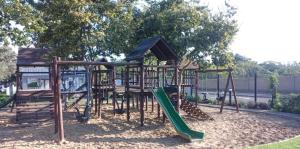 un parque infantil con un tobogán verde en Black Olive Haven, en Fourways