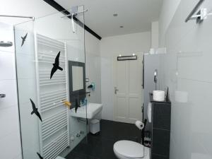 La salle de bains est pourvue de toilettes et d'une douche murale avec des oiseaux. dans l'établissement Fischer 2 Modern retreat, à Zinnowitz