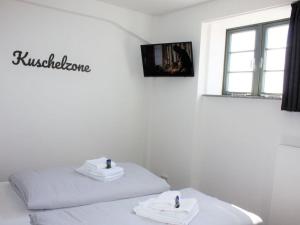 Dos camas en una habitación blanca con toallas. en Old town view in the Ohlerich warehouse en Wismar