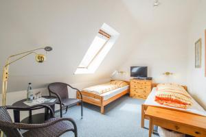 a bedroom with a bed and a couch and a table at Pension Lindenkrug in Thomsdorf