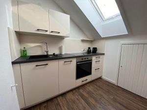 a kitchen with white cabinets and a skylight at Black Forest Nest in Todtmoos