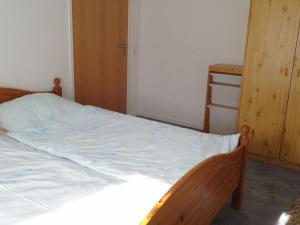 a bedroom with a white bed with a wooden frame at Saalendorf - Holidays in Saalendorf
