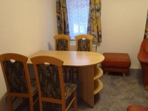 a dining room table with four chairs and a table at Saalendorf - Holidays in Saalendorf