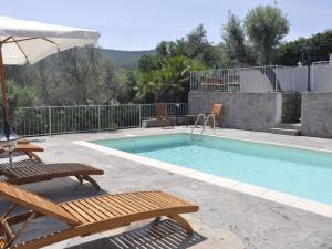 einen Pool mit 2 Stühlen und einem Sonnenschirm in der Unterkunft Lubagnu Vacanze in Castelsardo