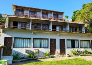 un edificio de apartamentos con balcones y ventanas en Pousada New Paradise en Búzios