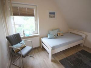 1 dormitorio con 1 cama, 1 silla y 1 ventana en Gerda in the Michaela House en Borkum
