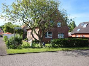 una casa de ladrillo con un árbol delante de ella en Gerda in the Michaela House en Borkum