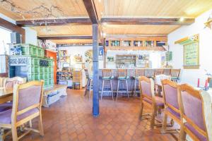 a dining room with a bar and some chairs at Pension Lindenkrug in Thomsdorf