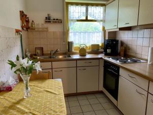 une cuisine avec une table et un vase de fleurs. dans l'établissement Tannenausblick Schmidt, à Oberhof