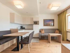 eine Küche und ein Wohnzimmer mit einem Tisch und einem Sofa in der Unterkunft in het Aparthotel Panorama in Gais