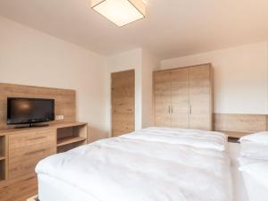 a bedroom with a bed and a flat screen tv at in het Aparthotel Panorama in Gais