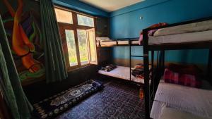 Zimmer mit 2 Etagenbetten und einem Fenster in der Unterkunft Formosa Hostel & Cafe in Kasol