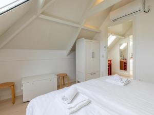 1 dormitorio blanco con 2 camas y ventana en Enjoy Villa Querina, en Koudekerke