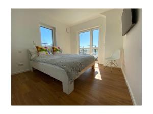 1 dormitorio con 1 cama en una habitación con ventanas en "Penthouse apartment on the water" en Rechlin
