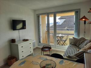 uma sala de estar com um sofá, uma mesa e uma janela em Appartement Seignosse, 1 pièce, 2 personnes - FR-1-239-871 em Seignosse