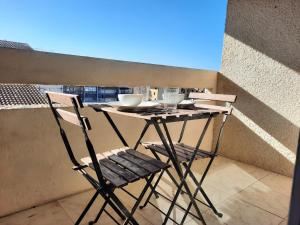 a table and two chairs sitting on a balcony at Appartement Seignosse, 1 pièce, 2 personnes - FR-1-239-871 in Seignosse