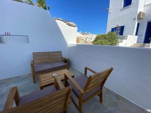 two wooden chairs and tables on a balcony at Evdokia's House Amorgos-Chora in Amorgos