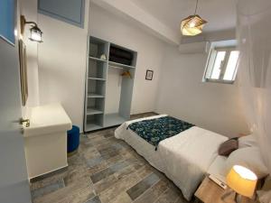 ein kleines Schlafzimmer mit einem Bett und einem Badezimmer in der Unterkunft Evdokia's House Amorgos-Chora in Amorgós
