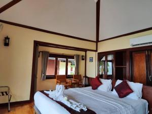 a bedroom with two beds and a table and chairs at Koh Mook Sivalai Beach Resort in Ko Mook