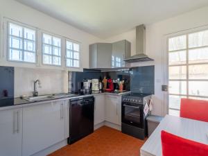 a kitchen with white cabinets and black appliances at Maison 3* à Mimizan Plage, 6 pers, jardin clos, proche plages et activités - FR-1-50-110 in Mimizan +4 photos