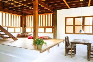 チェンマイにあるresort hoshihanaの木製テーブルと椅子付きの広いリビングルーム