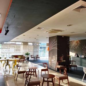 a restaurant with tables and chairs in a building at Go Hotels Plus Mandaluyong in Manila