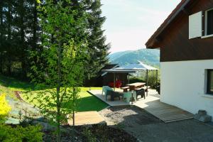 a backyard with a picnic table and a gazebo at Le petit coin de Jeanne et Marcel Maison de vacances La Bresse in La Bresse