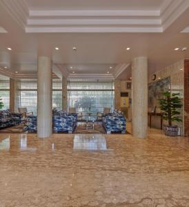 een lobby met zuilen en banken in een gebouw bij Regent Hotel Andheri in Mumbai