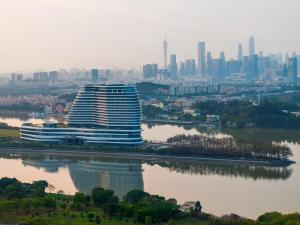 a large building next to a river with a city at Vignette Collection The Xanadu Guangzhou, an IHG Hotel in Guangzhou