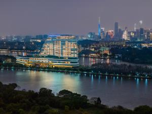 広州市にあるVignette Collection The Xanadu Guangzhou, an IHG Hotelの川上の大きな建物