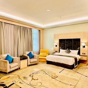 a hotel room with a bed and two chairs at أستديو فندقي ديلوكس in Jazan