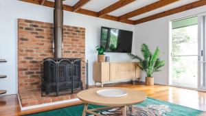 a living room with a brick fireplace and a table at Nantucket Cottage in Flinders in Flinders