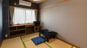 a small room with a table and a window at Tabist Oyado Chitose in Kazuno