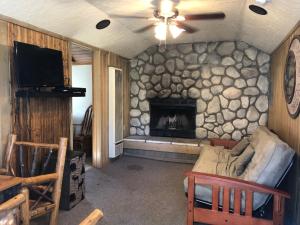 uma sala de estar com uma lareira de pedra e um sofá em Creek Runner's Lodge em Big Bear Lake