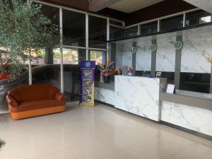 een lobby met een stoel en een balie in een gebouw bij Hotel Kembang Joyo in Palu