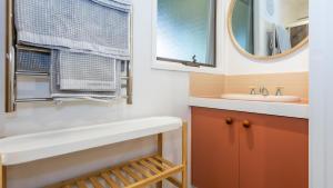 a bathroom with a sink and a mirror at Nantucket Cottage in Flinders in Flinders +38 photos