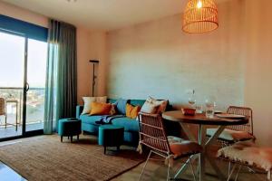 a living room with a blue couch and a table at L'Ampolla, sol y mar in L'Ampolla