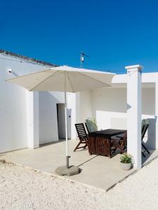 Villa Filou في سانتا لوسيا: مظلة بيضاء على فناء مع طاولة وكراسي