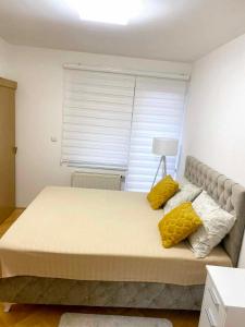1 dormitorio con 1 cama grande con almohadas amarillas en CENTAR, en Brčko