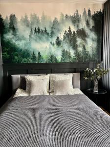 una camera da letto con un grande dipinto di una foresta di Apartament Przytulny 5 - Las, self check in, dworzec PKP a Rzeszów