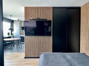 a room with a bed and a wooden wall at Apartament Przytulny 5 - Las, self check in, dworzec PKP in Rzeszów