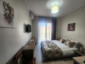 1 dormitorio con cama, escritorio y ventana en Apartments On Vaja Pshavela en Batumi