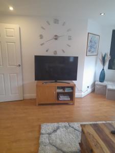 a living room with a large clock on the wall at Aston Apartment 4 -Secure Parking in Birmingham
