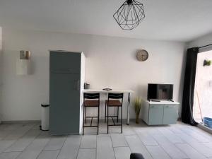 een woonkamer met een tafel en een koelkast bij Appartement à Sete in Sète