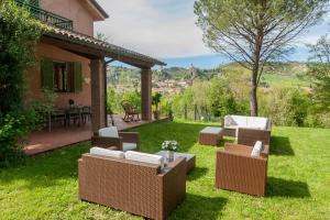 un patio con muebles de mimbre en Villa delle rose Brisighella, en Brisighella